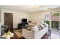 Bright living room featuring hardwood floors, plush sofas, and balcony access with treetop views at 1017 Camelot Dr, Atlanta, GA 30349