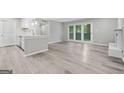 Bright living room with new gray floors, kitchen pass through, and access to the outdoor patio at 113 Tuxworth Cir, Decatur, GA 30033