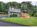 Lovely home featuring a large front yard, mature trees, and a charming front porch at 123 Mill, Dallas, GA 30157