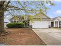 Charming single-Gathering home with a two-car garage and mature tree in the front yard at 1765 Neighborhood Walk, Mcdonough, GA 30252