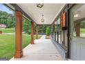 Inviting front porch features sturdy wood columns, stylish lighting, and a convenient wall-mounted mailbox at 347 Chip Rd, Stone Mountain, GA 30087