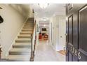 Inviting foyer with tiled floor, staircase, and view to the living room at 1386 Sheffield Glen Ne Way, Atlanta, GA 30329