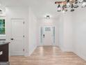 Bright entryway featuring wood-look floors, white trim, rustic lighting and a frosted glass front door at 5745 Westwood Dr, Cumming, GA 30040