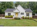 Charming single-story home with a yellow front door, well-manicured lawn, and lush green shrubbery at 5745 Westwood Dr, Cumming, GA 30040