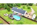 Aerial view of a home's backyard featuring a pool, deck, and ample green space at 1195 New Hope Rd, Locust Grove, GA 30248