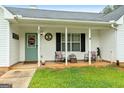 Charming front porch with rocking chairs and a decorative welcome sign on the front door at 1195 New Hope Rd, Locust Grove, GA 30248