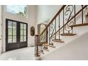 Elegant foyer with marble flooring, decorative iron banister, and leaded glass double front doors at 5940 Plantation Dr, Roswell, GA 30075