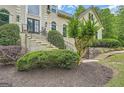 Beautiful landscaped front yard featuring a stairway to the home's entrance and mature plantings at 5940 Plantation Dr, Roswell, GA 30075