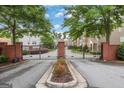 Gated community entrance with brick columns, black iron gates, and landscaped median at 1300 Hopkins Dr, Decatur, GA 30033