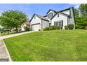 Traditional home offers manicured lawn, a two-car garage, and a side perspective of the well-kept yard at 1535 Fenmore St, Lithia Springs, GA 30122