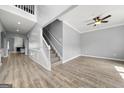 Spacious open-concept living room with hardwood floors and staircase featuring white railings at 1535 Fenmore St, Lithia Springs, GA 30122