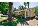 Lovely two-story yellow home with a charming front porch surrounded by mature trees and landscaping at 381 Cherokee Se Ave, Atlanta, GA 30312
