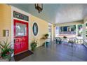 Inviting front porch with a red door, vintage furniture, and a view of a neighboring home at 381 Cherokee Se Ave, Atlanta, GA 30312