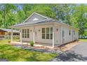 Side view of this home showing the porch and dark driveway at 23 Skyland W Dr, Locust Grove, GA 30248