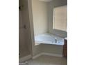 Bathroom featuring a corner tub, separate shower, and window with blinds at 8170 Oakley Cir # 2, Union City, GA 30291