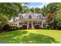 Traditional-style home with a manicured lawn, mature trees, and a covered front porch with columns at 220 Broadmoor Dr, Fayetteville, GA 30215