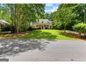 Traditional home with a lush green lawn and mature trees, viewed from the street at 220 Broadmoor Dr, Fayetteville, GA 30215