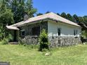 Stone and siding exterior view of a home with some overgrown vegetation and a large yard at 72 N Pomona N Rd, Hampton, GA 30228