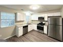 Bright kitchen features stainless steel appliances, white cabinets, and granite countertops at 1362 Mill Lake Cir, Stone Mountain, GA 30088