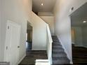 Bright foyer featuring hardwood floors and a staircase leading to the second level, with an open doorway and neutral walls at 142 Tye St, Stockbridge, GA 30281