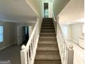 Inviting staircase featuring carpeted steps and white railings leading to the upper level at 2146 Wingfoot Pl, Decatur, GA 30035