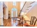 Welcoming foyer with hardwood floors, staircase, decorative chandelier, and natural light at 235 Ashley Forest Dr, Fayetteville, GA 30214