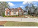 Charming brick home with manicured lawn, lush landscaping, and a welcoming driveway at 612 Champions Dr, Mcdonough, GA 30253