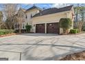 Rear view of a home showcasing a spacious driveway and two-car garage at 612 Champions Dr, Mcdonough, GA 30253