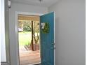 Light filled entryway featuring a blue front door adorned with a green wreath at 803 Pointe Trl, Locust Grove, GA 30248