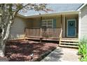 Inviting home exterior featuring a quaint porch with wood trim and a blue front door at 803 Pointe Trl, Locust Grove, GA 30248