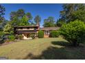 Traditional home showcasing its lush landscaping, brick exterior, and manicured lawn on a sunny day at 6214 Crestview Se Dr, Covington, GA 30014
