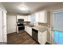 Bright kitchen featuring granite countertops, stainless steel appliances, white cabinetry and wood-look vinyl flooring at 9124 Comstock Ct, Covington, GA 30014