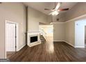 Inviting living room with a fireplace, high ceilings, wood-look vinyl flooring, and staircase access to the second floor at 9124 Comstock Ct, Covington, GA 30014