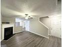 Inviting living room with a cozy fireplace, neutral paint, and modern laminate flooring at 408 Kendall Ln, Mcdonough, GA 30253