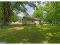 A single-story home with a big backyard and lush, green lawn, framed by mature trees at 525 Baker Nw Cir, Atlanta, GA 30318
