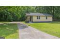 A single-story home surrounded by a beautiful lawn and mature trees, complete with a long driveway at 525 Baker Nw Cir, Atlanta, GA 30318