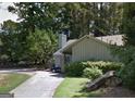 View of the home with mature trees, and a long driveway leading to a cozy facade at 8636 Woodside Ln, Jonesboro, GA 30238