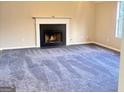 Comfortable living room with neutral walls, a fireplace, and soft gray carpeting at 4411 Ward Bluff Ct, Ellenwood, GA 30294