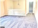 Spacious living room with plush gray carpeting and a white railing at 4411 Ward Bluff Ct, Ellenwood, GA 30294