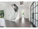 Bright foyer with hardwood floors, a staircase with glass railing, and modern fixtures at 115 Thome, Alpharetta, GA 30022