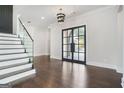 Elegant entryway features hardwood floors, staircase with glass railing, and modern lighting at 115 Thome, Alpharetta, GA 30022