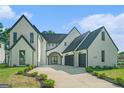 Charming two-story home with white brick, black trim, a driveway and lovely landscaping at 115 Thome, Alpharetta, GA 30022