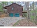 Exterior view of a rustic home featuring a two-car garage and upper deck at 3452 Monica Sw Ln, Conyers, GA 30094