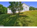 Spacious backyard with a gentle slope, featuring mature trees and ample green space at 221 Ashley Trace Dr, Locust Grove, GA 30248
