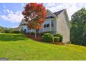 Two story home on a gently sloping lot with manicured lawn and mature landscaping at 221 Ashley Trace Dr, Locust Grove, GA 30248