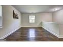 Upstairs hallway boasts gleaming wood floors and ample natural light from the window at 1026 Ponderosa Park Dr, Forest Park, GA 30297