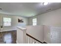 Bright hallway landing with wood floors and fresh paint leading to the home's entrance at 1026 Ponderosa Park Dr, Forest Park, GA 30297
