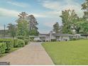 View of home from driveway and a glimpse of the lake behind the property at 270 E James Cir, Hampton, GA 30228