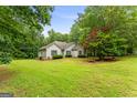Beautifully landscaped home on a lush green lawn surrounded by trees, offering a serene and inviting curb appeal at 40 Wenham Ln, Sharpsburg, GA 30277