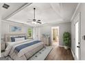 Bright main bedroom with a tray ceiling, ceiling fan, wood floors, and an en-suite bathroom at 40 Wenham Ln, Sharpsburg, GA 30277